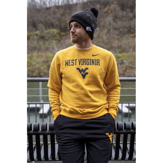 Model wearing a gold Nike WVU crew sweatshirt with West Virginia over the Flying WV Logo front screen print